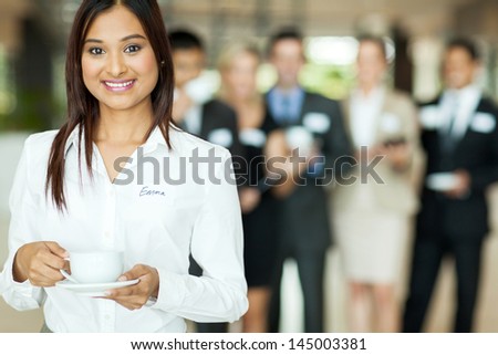smiling indian businesswoman having coffee during conference break