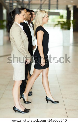 beautiful businesswoman stepping forward out of crowd