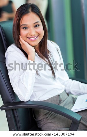 portrait of smiling indian business woman sitting in office