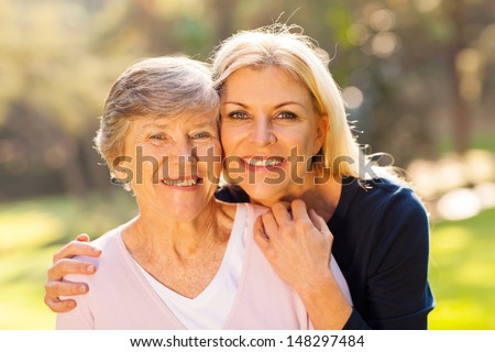 smiling senior woman and middle aged daughter outdoors closeup portrait