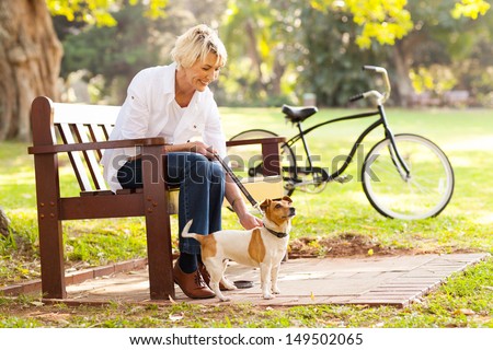 happy mature woman with pet dog outdoors