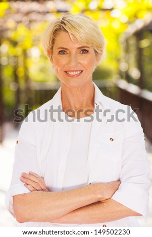 pretty middle aged woman with arms folded portrait outdoors