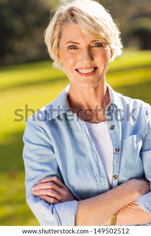 portrait of middle aged woman with arms crossed outdoors