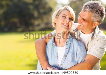 cute middle aged couple embracing outdoors