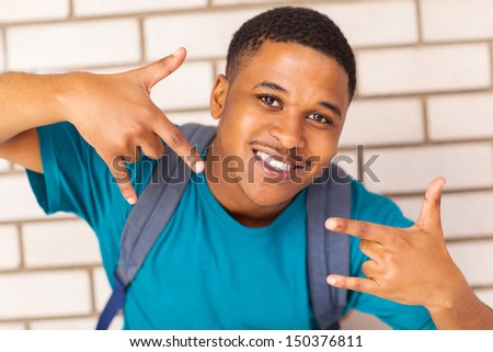 cheerful afro american college student with a cool hand sign