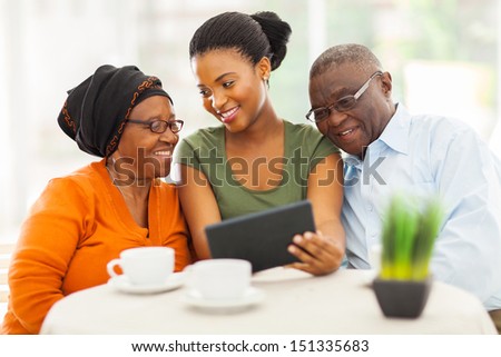 cheerful african family at home using tablet pc