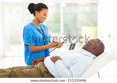 beautiful african female doctor consulting senior patient in office