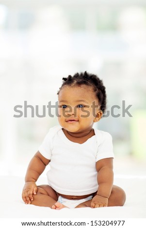 pretty cute african baby girl sitting on bed