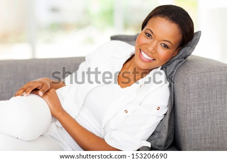 happy african woman lying on a couch