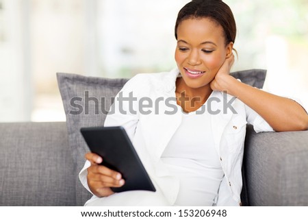 pretty african woman using tablet computer at home