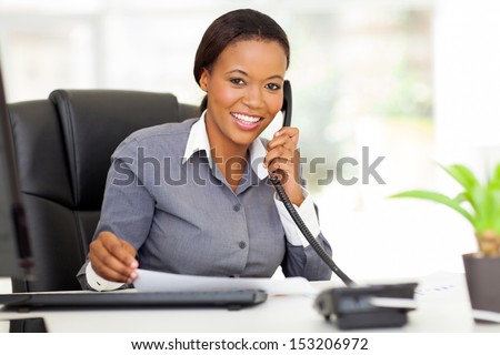 attractive female african office worker talking on phone