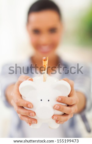 woman holding piggybank with banknote