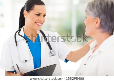 friendly female doctor comforting middle aged patient in hospital