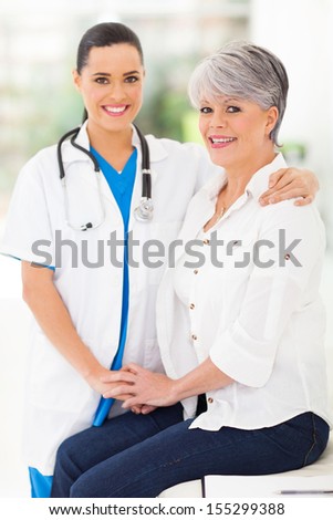 caring nurse comforting middle aged patient in office