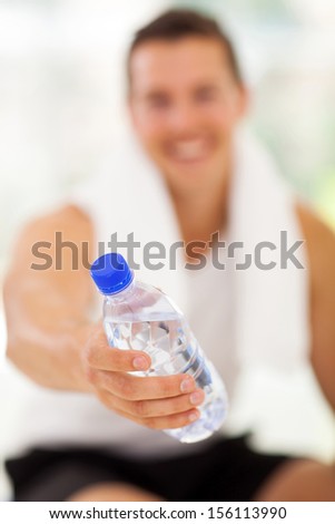 young man giving water bottle in gym