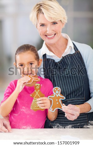 beautiful little girl eating gingerbread cookie her grandma just baked