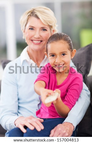 beautiful little girl watching television with her grandma