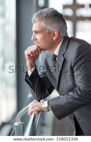 thoughtful senior businessman looking out the window
