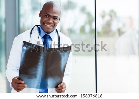 happy african american medical worker holding patient\'s x-ray in office