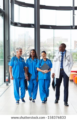 group of professional health care workers walking in hospital