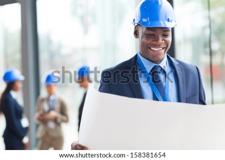 smart african construction businessman reading blue print