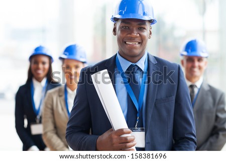 handsome african male architect holding blue print and team