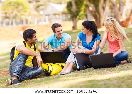 group of cheerful university students relaxing outdoors on campus