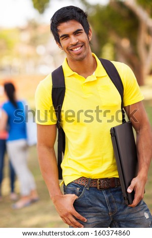 handsome male indian university student standing outdoors on campus