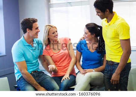 cheerful university students chatting in lecture hall during break