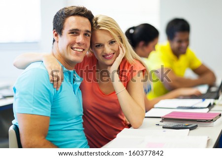 happy college couple in lecture room looking at the camera