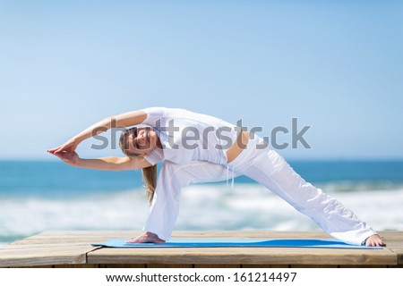 fit middle aged woman exercising outdoors on beach