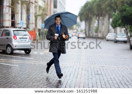 young news correspondent rushing for breaking news in raining day