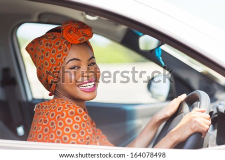 cheerful african female driver inside a car