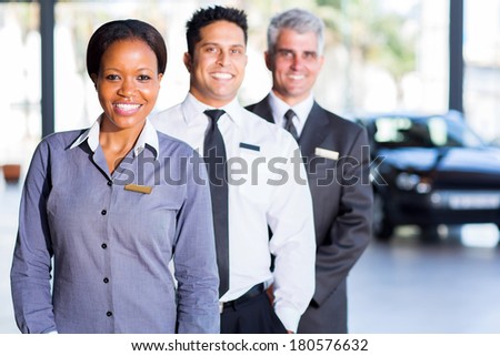 multiracial vehicle sales team inside car showroom