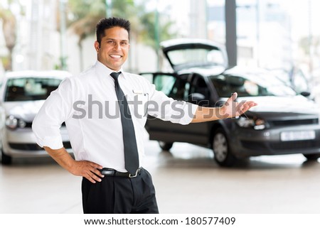 car dealer presenting new vehicle in showroom