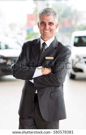 happy middle aged man working at car dealership