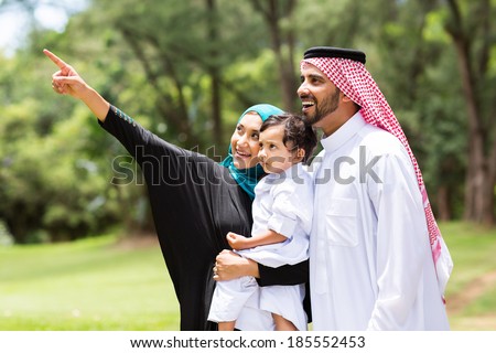 cute arabian family looking and pointing in the forest