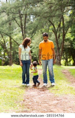 cute young indian couple with baby boy walking outdoors
