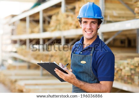 portrait of smiling industrial worker with clipboard