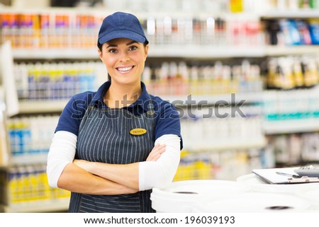 beautiful young female supermarket worker with arms crossed