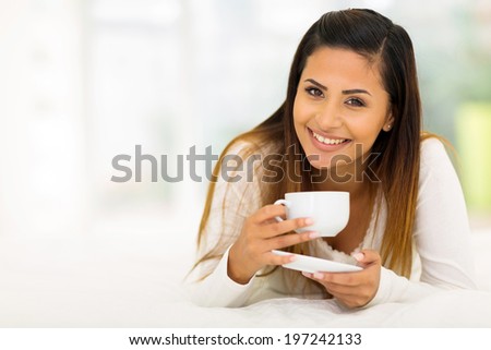beautiful young woman drinking coffee in bed