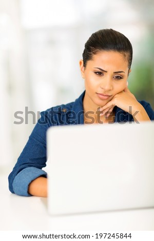 worried young woman looking at computer screen