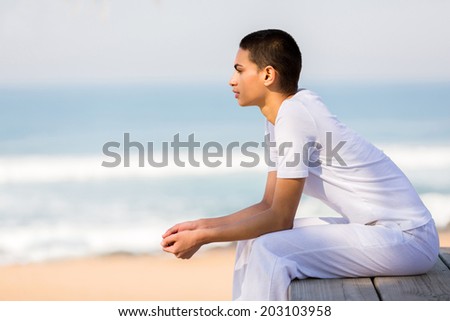 beautiful young woman looking into distance on the beach