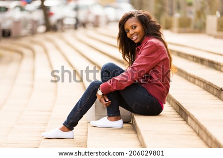 beautiful african woman outdoors sitting on steps