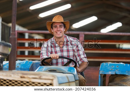 happy young farmer driving tractor