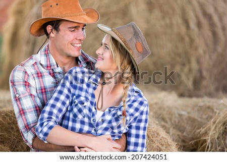 loving young american western couple hugging in barn
