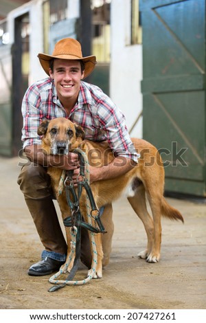 happy horse farm owner and his dog in stables