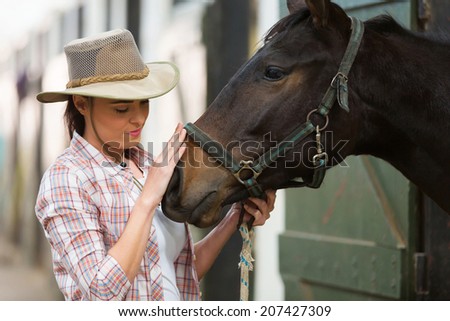 caring cowgirl talking to a horse in farm house