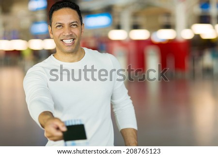 handsome mature man handing over air ticket at check in counter