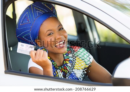 happy african woman showing her driver\'s license she just got
